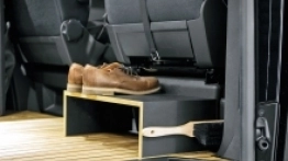 Dodatkowy podnóżek zamontowany za fotelem pasażera przymocowany jest do podłogi przy pomocy magnetycznej blokady. Na magnes trzyma się także szczotka do butów, dla której miejsce projektant przewidział od strony wejścia do kampera.  - zdjęcie 6